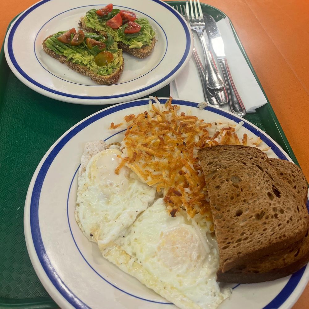 Eggs, crispy hash browns and toast, with avocado toast on the side.